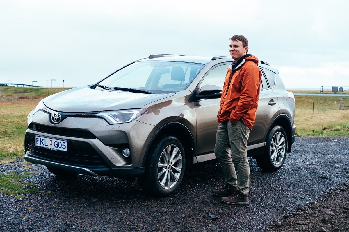 Man standing next to a car in Iceland.