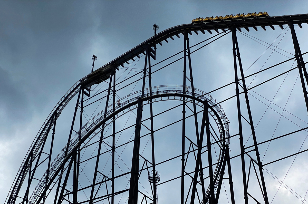 Roller coaster tracks with gold painted car near the edge of a steep drop