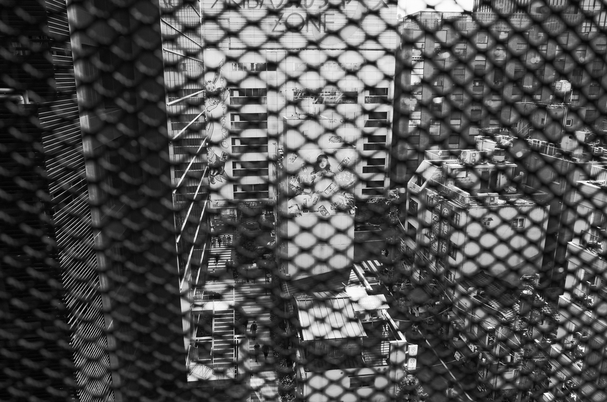 View of Akihabara through a wired mesh screen.
