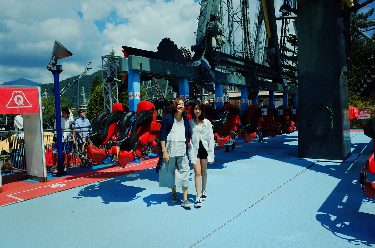 Two people in front of the Paniclock ride at Fuji-Q Highland